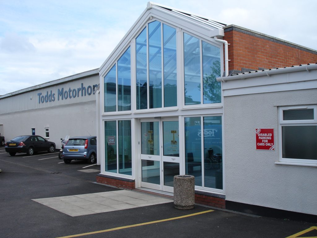 White-framed glass entrance on the Todds Motorhomes building